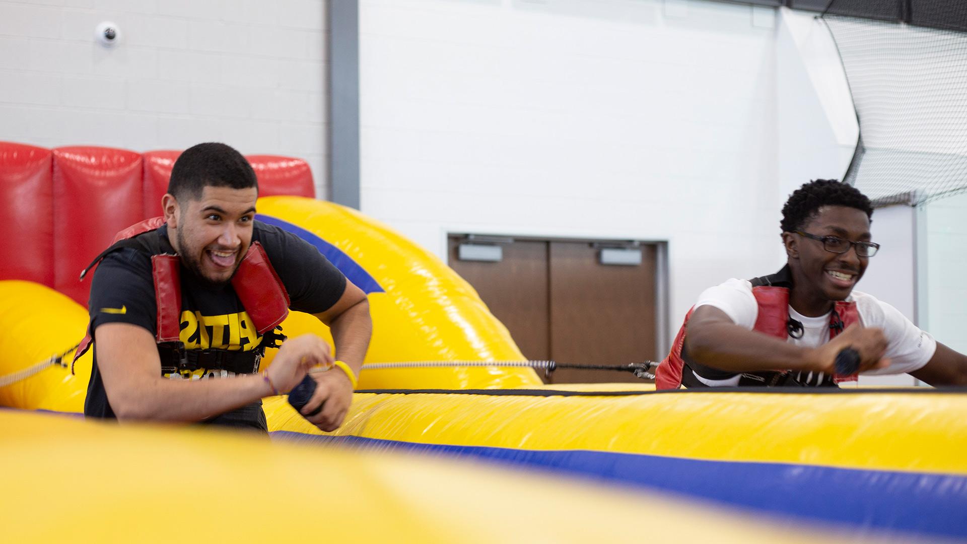 Two students pulling ropes in an inflatable game